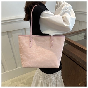 Detail view of pink tote bag showing unique crinkled paper texture and durable shoulder strap
