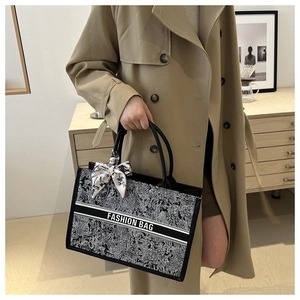 Detail der bedruckten Canvas-Tasche mit Seidentuch am Griff und FASHION BAG Logo