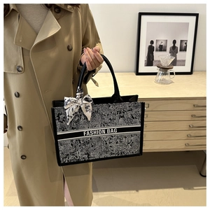 Detail of floral canvas tote bag with silk scarf accessory and Fashion Bag text print
