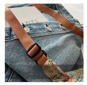 Détail de la bandoulière en nylon réglable et boucle en plastique du sac en denim