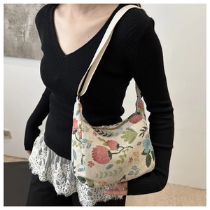Close-up of floral jacquard hobo bag with vintage pattern on white woven fabric
