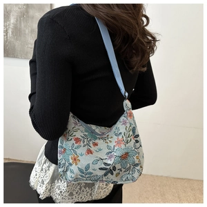 Détail du sac à bandoulière floral avec motifs ethniques et sangle en tissu bleu