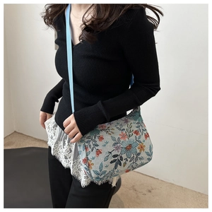 Détail du tissu jacquard floral vintage sur un sac bandoulière bleu ciel