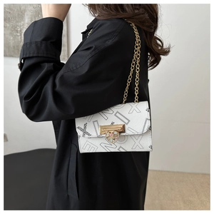 Detail of white chain bag featuring black letter prints and colorful heart metal clasp