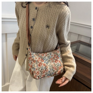 Close-up of vintage floral tapestry fabric and brown adjustable strap on the canvas tote bag