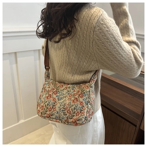 Détail du sac croissant vintage avec motif jacquard coloré et bandoulière marron