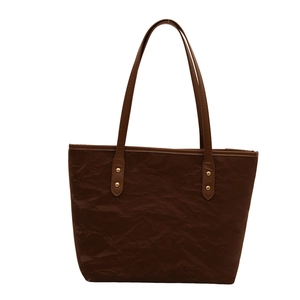 Vintage dark brown tote bag with pleated texture and long shoulder straps on white background