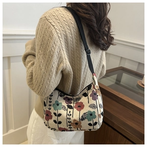 Détail d'un sac demi-lune rétro en jacquard fleuri avec bandoulière réglable