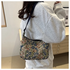 Detailed view of floral tapestry shoulder bag worn on shoulder for daily fashion style