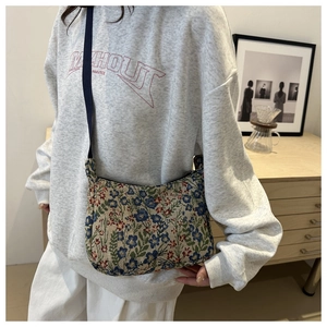 Detail of vintage floral crescent shoulder bag made of textured jacquard fabric