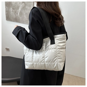Détail du sac cabas matelassé blanc avec bandoulières noires porté par un mannequin