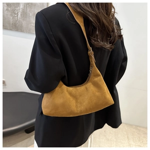 Sac hobo en daim marron porté à l'épaule montrant la vue arrière et la texture
