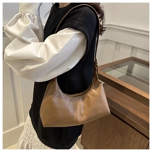 Détail d'un sac hobo en cuir marron clair en forme de croissant avec bandoulière réglable
