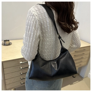 Vue détaillée d'un sac à bandoulière noir en forme de croissant en cuir vintage sur modèle
