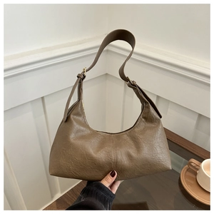 Détail du sac croissant marron vintage avec surpiqûres et finitions dorées