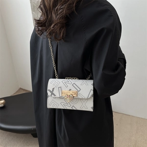Elegant white chain crossbody bag with black star prints and a heart-shaped metal lock