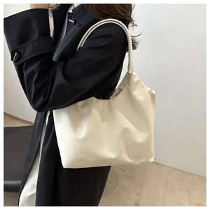 Chic beige leather tote bag shown on model's shoulder for minimalist style and scale