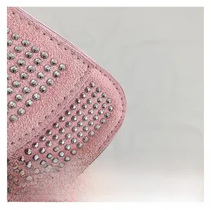 Detailansicht der rosa matten Ledertextur der Handtasche mit silbernen Metallnieten