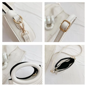 Detail view of white handbag featuring gold hardware, leather handle, and interior pocket
