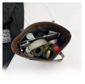 Vertical top view showing large capacity interior of brown tote bag with daily essentials