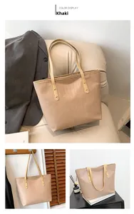 Detailed view of khaki crocodile pattern shoulder bag on minimalist furniture
