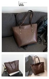 Detail of dark brown faux crocodile leather tote bag with elegant golden metal rivets