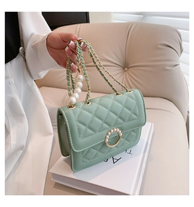 Détail du sac matelassé vert menthe avec chaîne dorée et élégants accents de perles