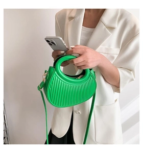 Detail of vibrant green tote with vertical embossing and circular cutout handle