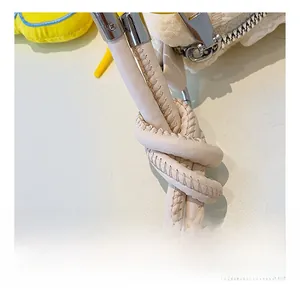Detail of cream leather shoulder strap with knot design and silver metal ring buckle
