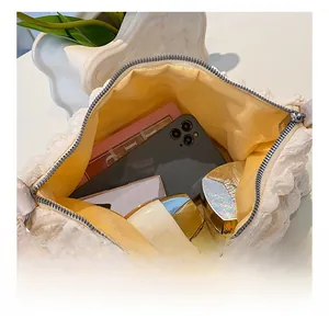 Interior view showing the large capacity of a white puffy textured cosmetic bag