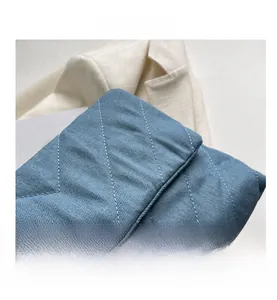 Gros plan sur le tissu matelassé bleu clair avec coutures en losange et texture coton