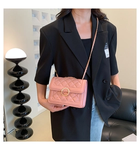Gros plan détaillé du sac matelassé rose avec boucle en perles et bandoulière chaîne