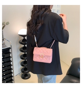 Détail du sac à bandoulière matelassé rose avec boucle perle et chaîne élégante