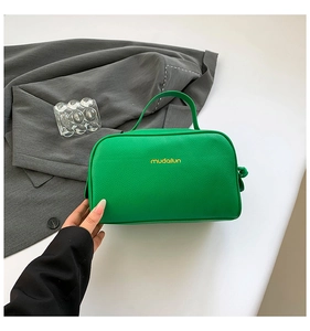 Close-up of bright green lychee grain PU leather makeup bag with gold zipper and handle
