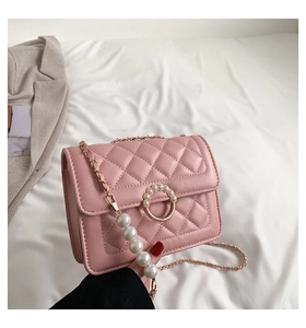 Détail d'un sac rose matelassé avec fermoir anneau perlé et bandoulière chaîne en perles