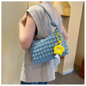 Detailed texture of light blue bubble shoulder bag with a yellow flower charm