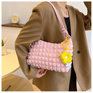 Detail of pink bubble texture bag with yellow flower charm and knot shoulder strap