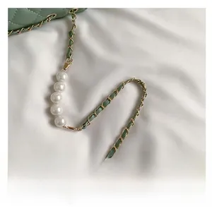Détail du sac matelassé vert menthe avec chaîne dorée et accents de perles blanches