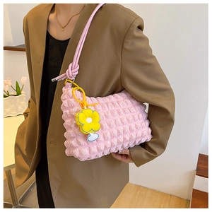 Detail of pink bubble texture shoulder bag with yellow flower charm on a model