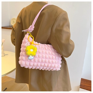 Pink bubble textured shoulder bag with a yellow sunflower charm and knotted strap detail