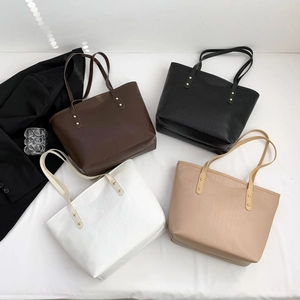 Flat lay view of crocodile pattern tote bags in dark brown, black, white, and beige
