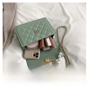 Vue intérieure du sac matelassé vert montrant la capacité pour téléphone et maquillage