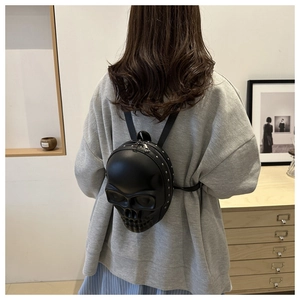 Détail du mini sac à dos tête de mort avec relief 3D et clous métalliques argentés