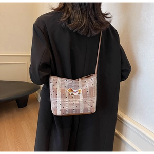 Detail of plaid crossbody bag with lace accents and cute animal patch on model