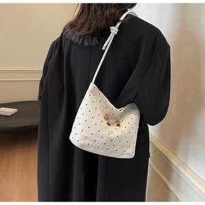 Detail of white polka dot bucket bag featuring cute 3D bear embroidery and knotted strap