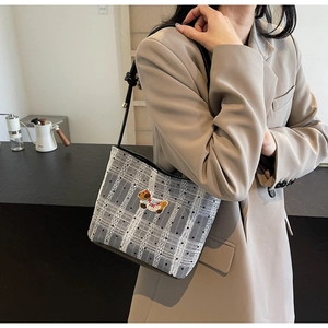 Chic underarm bag with plaid mesh and cute dog embroidery styled on shoulder