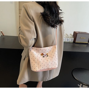 Pink polka dot bucket bag featuring a cute cartoon dog embroidery on a female model