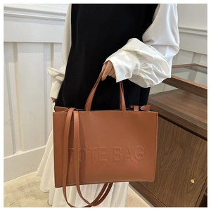 Brown vintage faux leather tote bag with embossed TOTE BAG lettering and long shoulder strap
