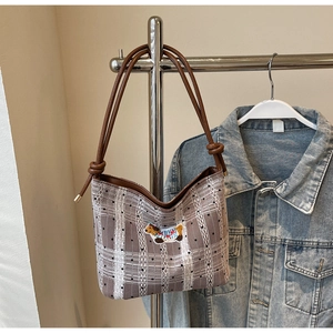 Detail of checkered tote bag featuring white lace trim and cute puppy embroidery patch