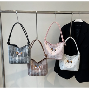 Detail view of four semi-circular underarm bags with cute dog embroidery on a metal hanger